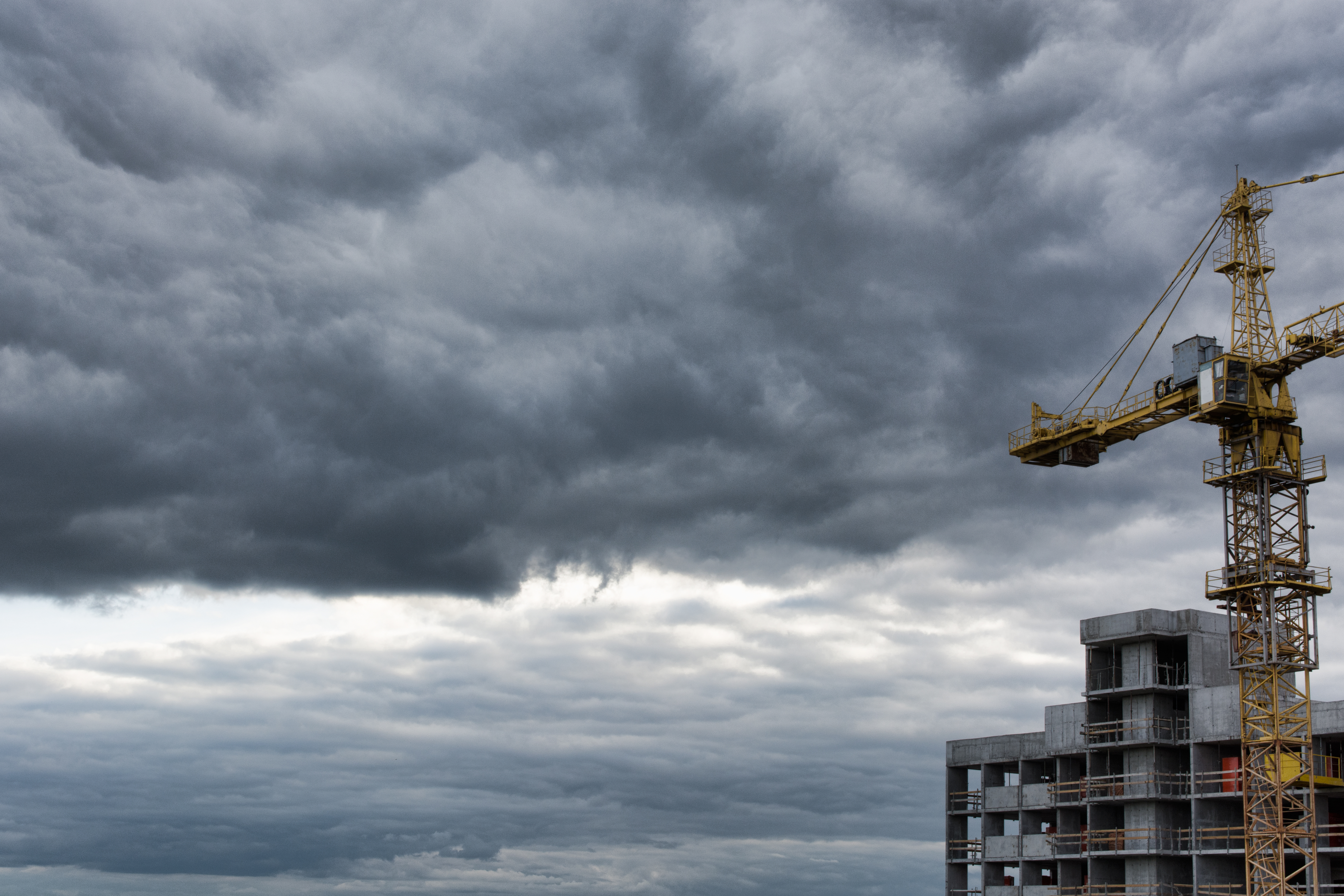 Industrial,Construction,Cranes,And,Building,Site,Over,Stormy,Sky.,Grunge